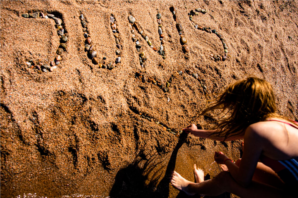 Barn skriver i sanden