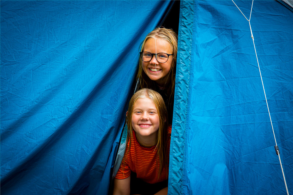 Barn som tittar ut ur tält